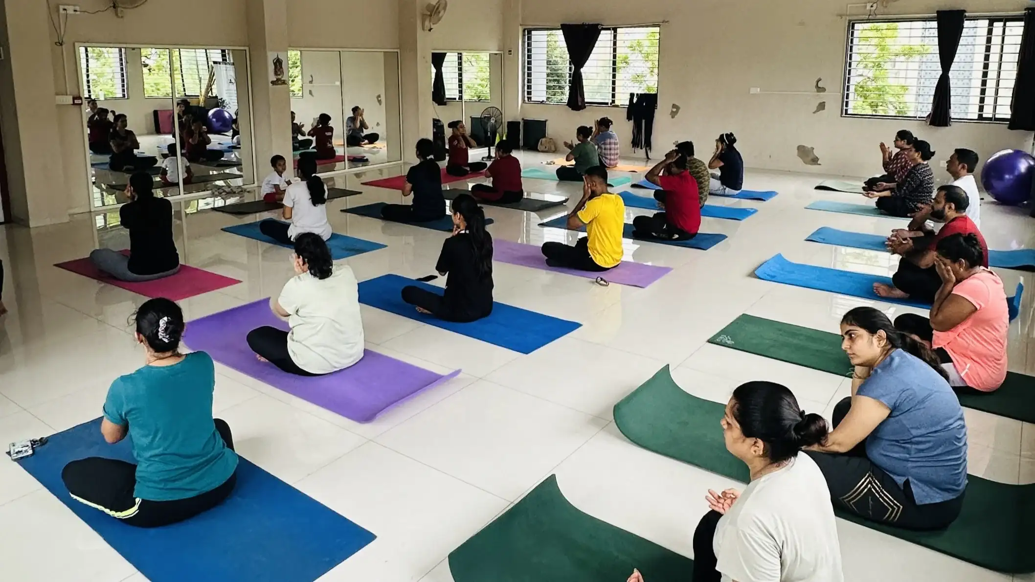 Practitioners engaged in a dynamic indoor yoga flow within our professional studio space.