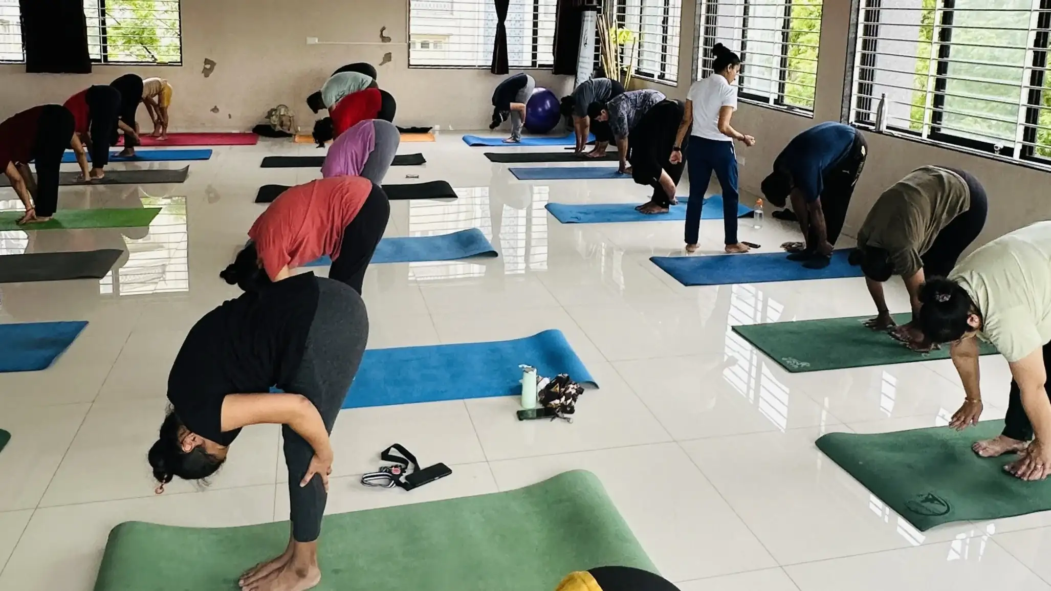 Students practicing intensive forward folds to boost metabolism and flexibility.