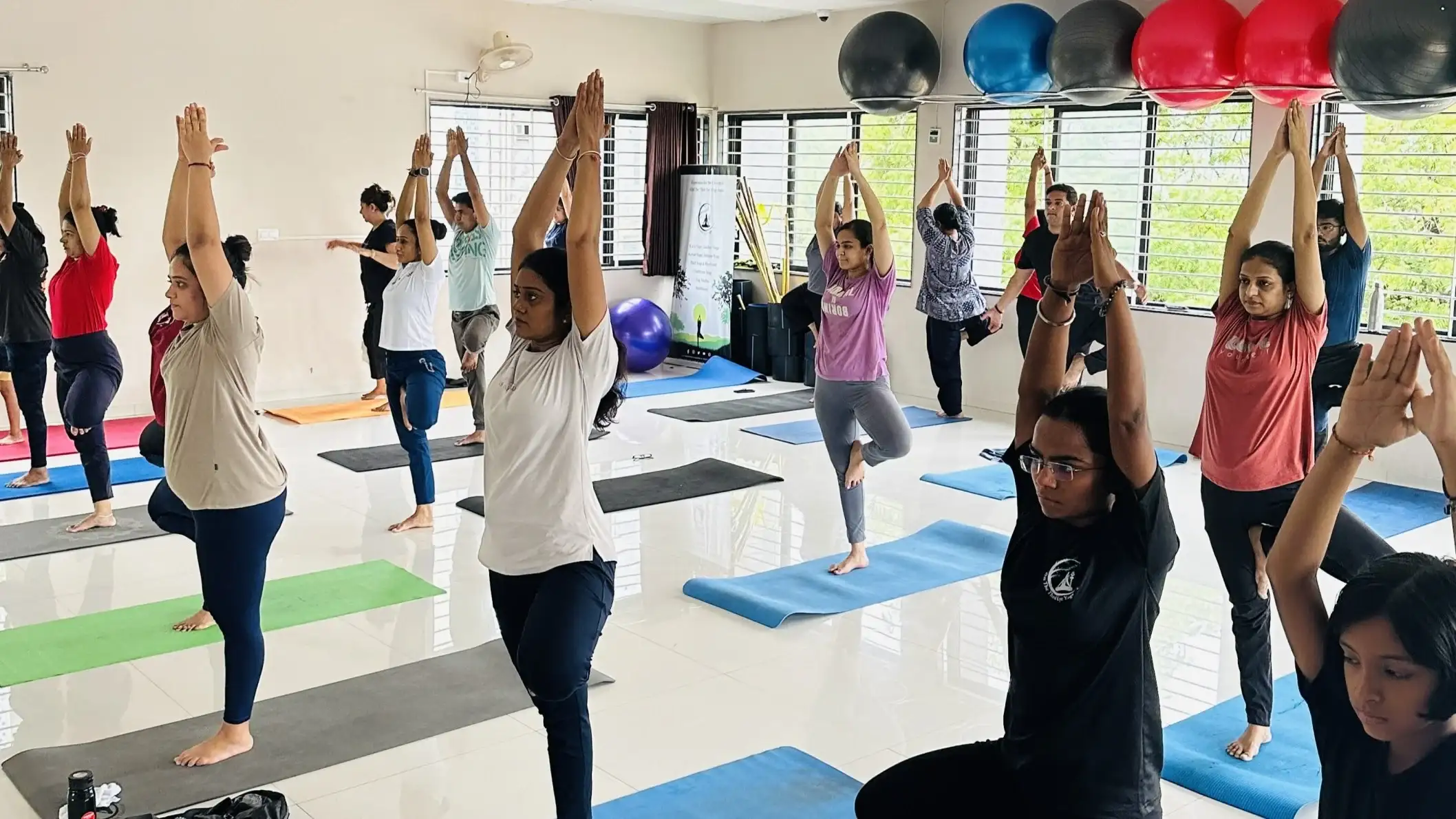 Demonstrating balance and concentration through the Tree pose in a group setting.