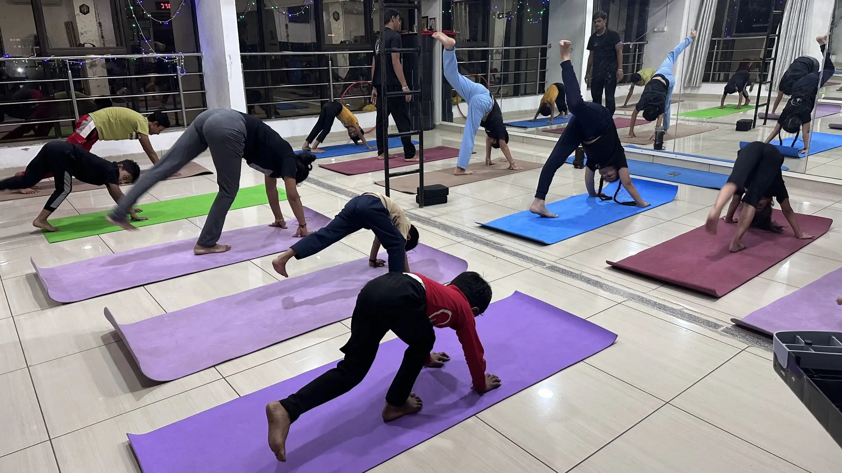 Synchronized group practice of Downward-Facing Dog for full-body stretching.